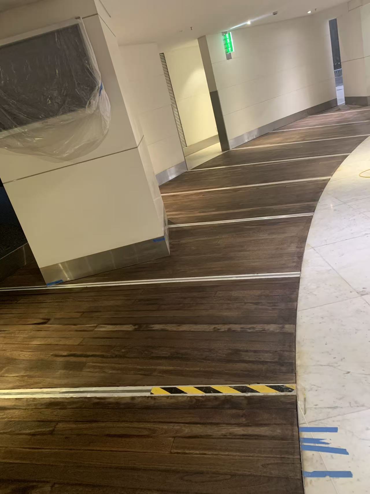 Building lobby timber floorboards with stain applied, Sydney