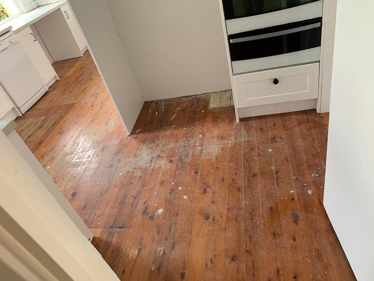 Old worn kitchen timber floorboards before sanding, Eastwood