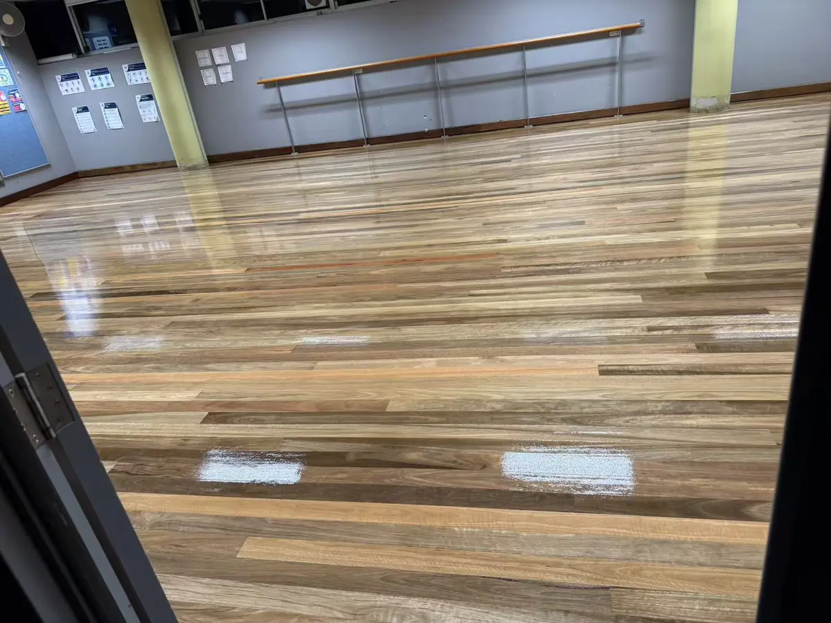 Restored timber floorboards in a Freshwater Senior Campus room, viewed toward built-in cabinets