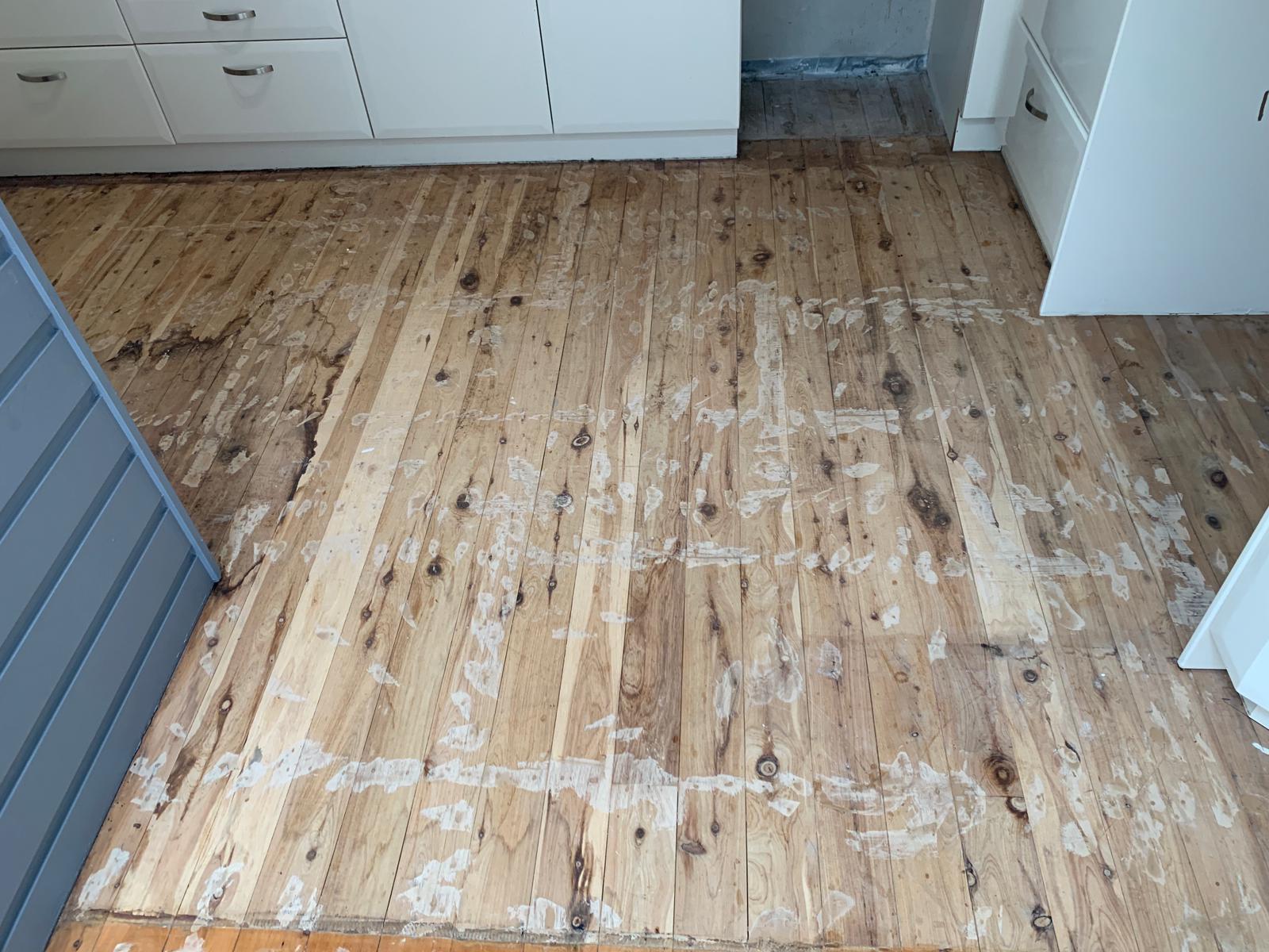 Kitchen floor showing sanded timber next to original finish, Jervis Bay